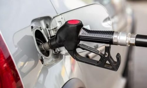gray-metallic-car-refueling-gas-station-closeup-with-selective-focus-blurry-man-background_636705-31